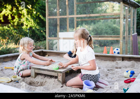 Mädchen spielen im Sandkasten Stockfoto