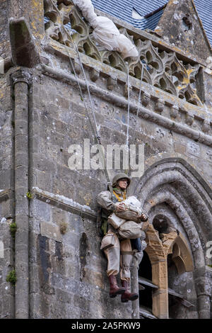 Denkmal für US 82nd Airborne Fallschirmjäger John Steele auf dem Dach der Kirche von Sainte-Mère-Église, Normandie, Frankreich Stockfoto