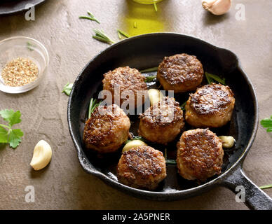 Nahaufnahme von Hackfleisch Schnitzel in der Pfanne über braunen Hintergrund. Stockfoto