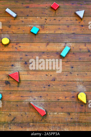 Nahaufnahme des Holz- Kletterwand mit bunten Griffen. Stockfoto