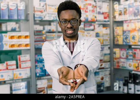 African-american Apotheker Mann mit Tabletten Pillen in die Hände. Des Menschen Hände halten eine Handvoll Medizin Pillen, Krankheiten zu behandeln. Stockfoto