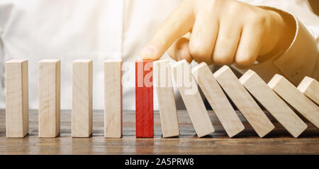 Geschäftsmann stoppt Domino fallen. Risk Management Konzept. Erfolgreiche Unternehmen und Problemlösung. Zuverlässige Führer. Stoppen Sie den zerstörenden Verfahren Stockfoto