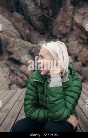 Junge Frau sitzt an einem Anlegesteg Stockfoto