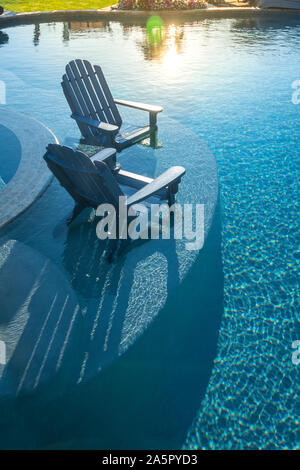 Zwei Adirondack Stühle im Pool Stockfoto