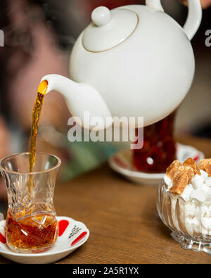 Schwarzer Tee von Teekanne in armudu Glas gegossen Stockfoto