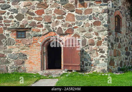 Mauer der alten Burg mit geöffneten Tür Stockfoto