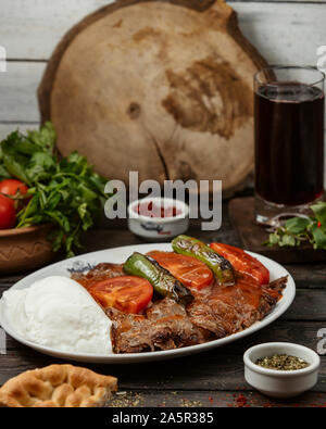 Iskender Kebab garniert mit Tomaten, Paprika, mit Joghurt serviert. Stockfoto