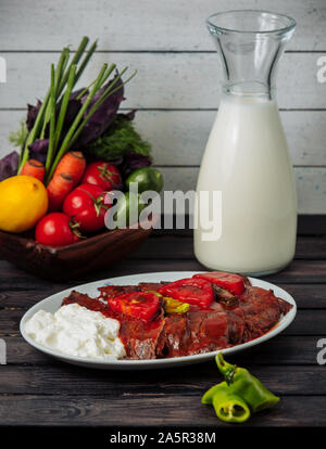 Iskender Kebab garniert mit Tomatensoße, mit Joghurt serviert. Stockfoto