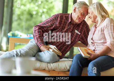 Pensionierte ältere Paar entspannt im Wohnzimmer mit Büchern Stockfoto