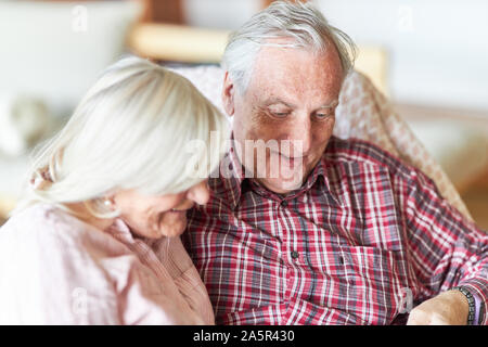 Happy Rentnerehepaar sitzt locker im Wohnzimmer Stockfoto