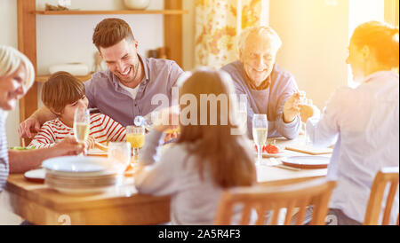 Erweiterte Familie mit Kindern und Großeltern sitzen am Tisch über dem Mittagessen Stockfoto