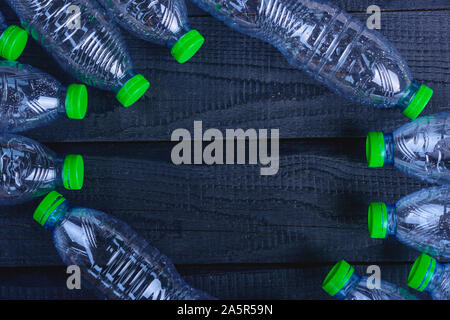 Frame Plastikflaschen Müll auf schwarzem Holz-, Umwelt Konzept recycelt Stockfoto