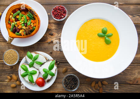 Kürbis creme Suppe mit Basilikum, gebackener Kürbis mit Gemüse: Karotten, Bohnen, Weiße, Bruschetta mit Frischkäse und Tomaten. Danksagung Stockfoto