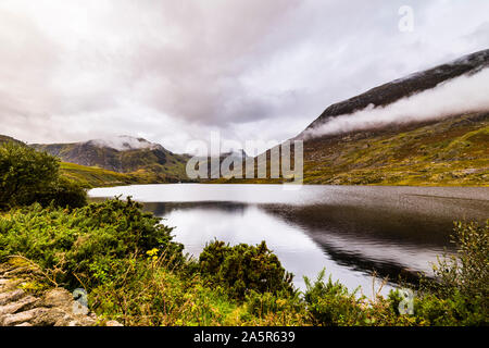 Noch Reflexionen und niedrige Wolken über Llyn Ogwen, Snowdonia National Park, North Wales, UK Stockfoto