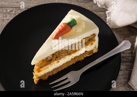 Süße Karottenkuchen Schicht auf einer Platte am Holztisch. Stockfoto