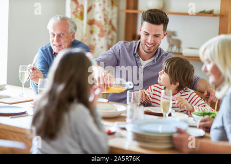 Erweiterte Familie in Abend- oder Mittagessen mit Großeltern und Enkel Stockfoto