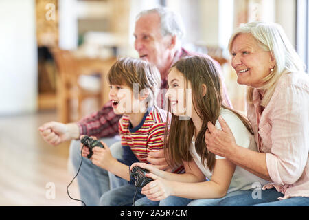 Familie mit Großeltern spielen video game Gaming vor Smart TV zu Hause Stockfoto