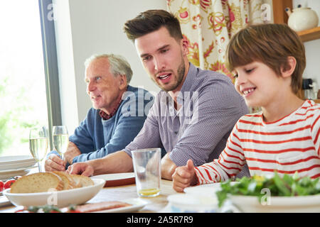 Erweiterte Familie mit Großvater und Enkel zum Mittag- oder Abendessen Stockfoto
