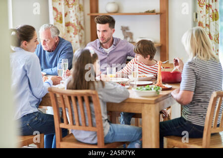 Erweiterte Familie mit Kindern und Großeltern mit Mittag- oder Abendessen Stockfoto