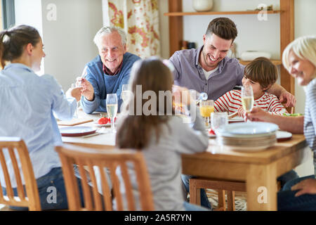 Glückliche Großfamilie mit den Großeltern und Enkelkinder mit Mittagessen Stockfoto