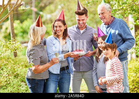 Erweiterte Familie mit Großeltern und Kinder feiert Geburtstag im Sommer im Garten Stockfoto