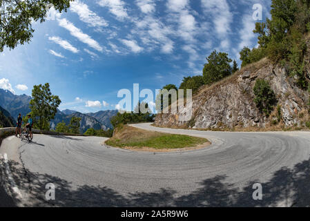 Radfahren Paar eine Pause auf einer der vielen Serpentinen nach Alpe d'Huez, Oisans, Französischen Alpen. Stockfoto