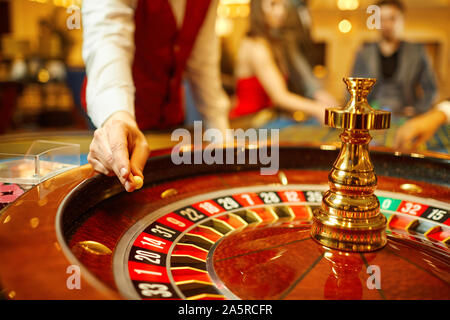 Der Croupier hält eine Kugel in einem Casino in seiner Hand. Stockfoto