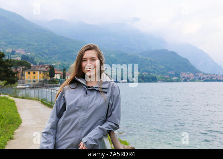 Junge Frau, die in der Nähe von Bannister, den Comer See und Alpen Berg im Hintergrund. Stockfoto