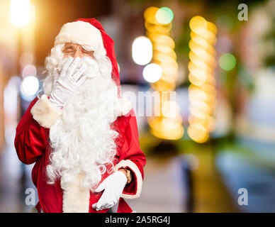 Mittleres Alter stattlicher Mann mit Santa Claus Kostüm und Bart stand gelangweilt Gähnen müde über den Mund mit der Hand. Rastlos und Schläfrigkeit. Stockfoto