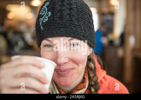 Eine Frau genießt eine Tasse Tee in einer Lodge am Mount Baker Skigebiet. Stockfoto