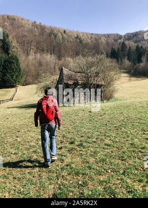 Rückansicht des Menschen vorwärts gehen zu abonded Holzhütte Stockfoto