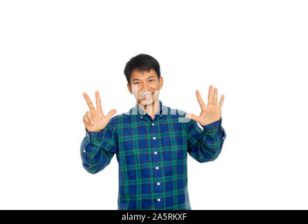 Die asiatische ungepflegte Mann in Blue Plaid Shirt ist die Zahl 8 Symbol, das durch seine Finger. Stockfoto