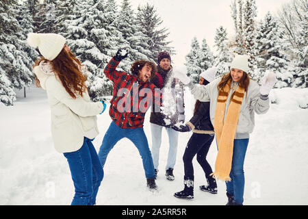 Junge Freunde im Winter Mäntel in Schneeballschlacht im Winter Natur Stockfoto