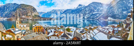 Der malerischen Panoramablick auf das Stadtbild von Hallstatt im Winter mit verschneiten Dächer der Altstadt von Stadthäusern, hohen Turm der Evangelischen Kirche (Kirche), ruhige Oberfläche der Halle Stockfoto