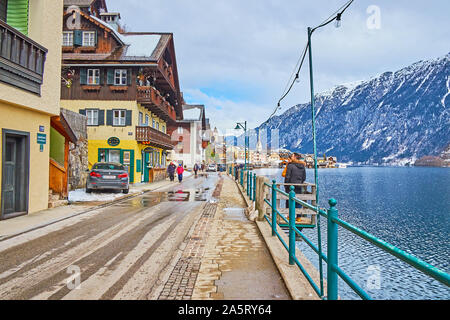 HALLSTATT, Österreich - 25. FEBRUAR 2019: Seestrasse erstreckt sich entlang der Ufer des Hallstätter See (See) und bietet eine große Menge an touristische Geschäfte, Cafés Stockfoto