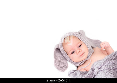 Little Baby 3 Monate in einem grauen Strickmütze mit Ohren. Weißer Hintergrund, kopieren. Portrait der kaukasischen Kind, süßes Kleinkind geballte Faust. Stockfoto