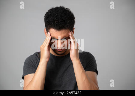 Hispanic Mann lächelnd im Studio mit grauem Hintergrund Stockfoto