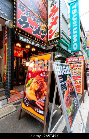 Tokio, Akihabara. Menü Boards auf Pflaster für Ramen Restaurant Eingang im Erdgeschoss und Rindersteak Hamburger Restaurant im zweiten Stock. Stockfoto