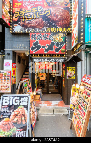 Tokio, Akihabara. Menü Boards auf Pflaster für Ramen Restaurant Eingang im Erdgeschoss und Rindersteak Hamburger Restaurant im zweiten Stock. Stockfoto