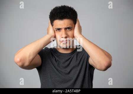 Hispanic Mann lächelnd im Studio mit grauem Hintergrund Stockfoto