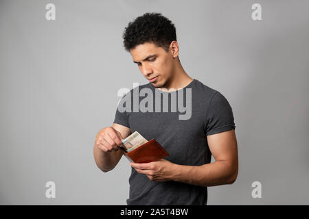 Hispanic Mann lächelnd im Studio mit grauem Hintergrund Stockfoto