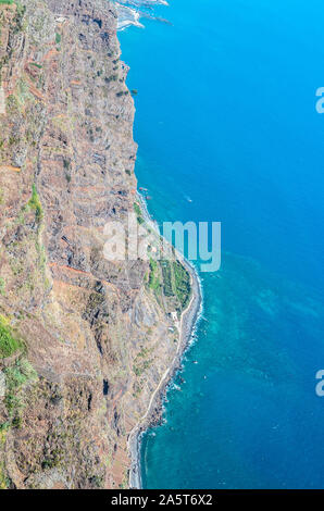 Luftaufnahme des blauen Atlantik und Madeira Küste. Stein Strand und die angrenzenden Felder an der Südküste der Insel Madeira, Portugal. Antenne Landschaft, schöne Natur. Natürlichen formen. Stockfoto