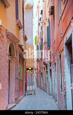 Schöne Gasse in Venedig, Italien. Rosa und Orange Fassaden der alten Gebäude. Stockfoto
