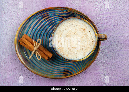 Türkische Salep oder Sahlep mit Zimtstangen/Weihnachten Eierlikör. Mit Zimtstangen und Orchideenblüte serviert. Stockfoto