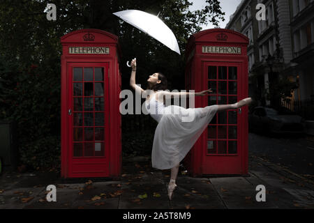 London, Großbritannien. Oktober 2019. Weltballetttag: Rebecca Olarescu, Studentin der Royal Academy of Dance (Rad), tritt am frühen Abend in der Nähe von zwei roten Telefonzellen in Primrose Hill im Nordwesten Londons auf. Guy Corbishley/Alamy Live News Stockfoto