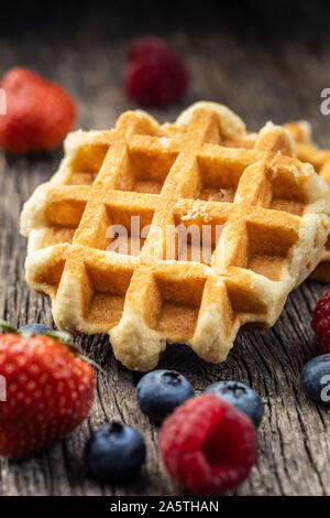 Waffeln mit Heidelbeeren und Himbeeren auf alten Holztisch. Stockfoto