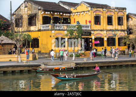 Frau auf einem Boot mit Hoi An street scene im Hintergrund Stockfoto