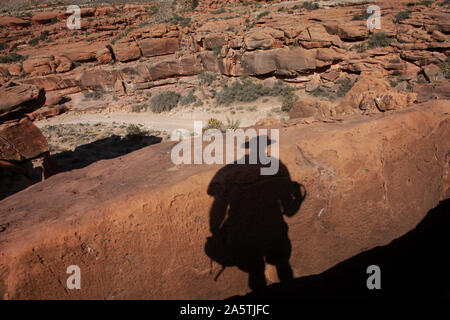 Schatten Silhouette des Fotografen auf dem roten Felsen in der Wüste Landschaft Stockfoto