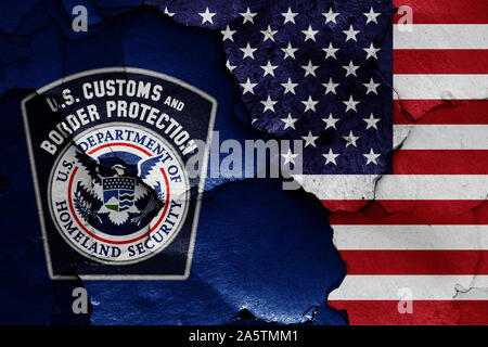 Flaggen der US-amerikanischen Zoll- und Grenzschutzbehörden und USA malte auf Risse an der Wand Stockfoto