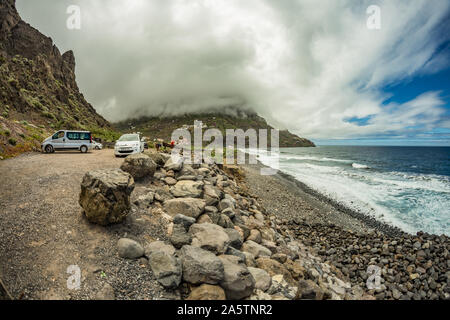 Blick auf die Santa Catalina Strand. Riesige Steine und Kiesel um. Niedrig hängenden dichte Wolken über dem Meer Wellen am Strand. La Gomera, Kanarische Inseln, Stockfoto